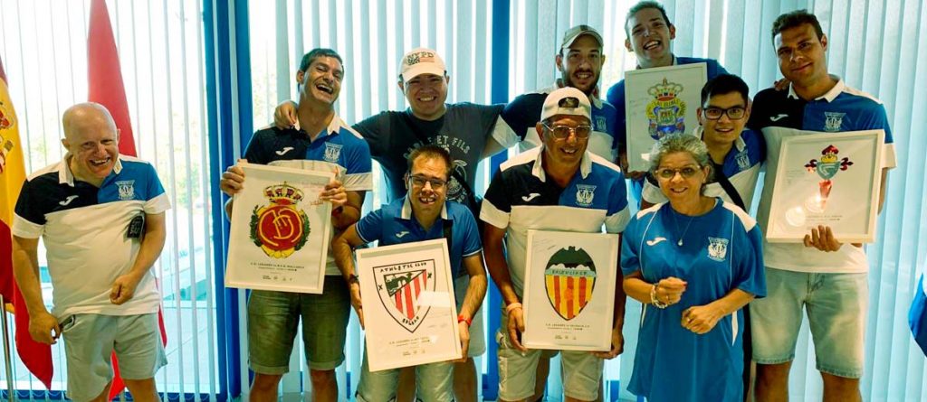 Integrantes del CD Leganés Genuine con los cuadros con los escudos de los equipos visitantes