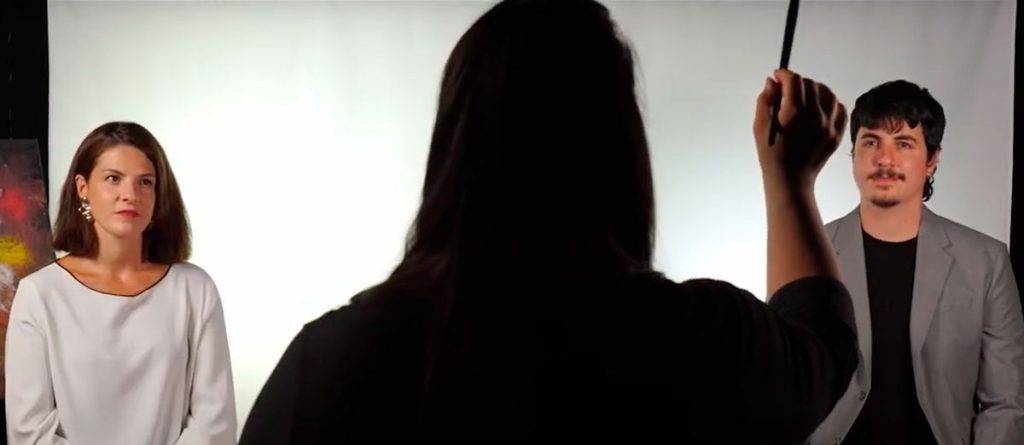 Fotograma del vídeo de promoción de los teambuilding liderados por personas con discapacidad. Dos personas prestan atención a una tercera cuyo rostro no vemos