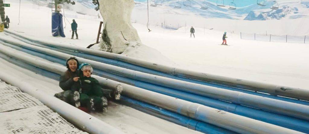 Niño y su apoyo disfrutando de la nieve en Xanadú
